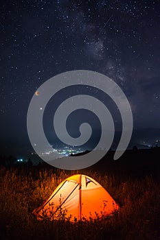 Camping tent in a mountain valley with total moon eclipse