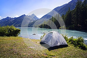 Camping tent in the nature. Mountains and lake