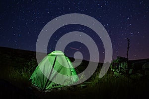 Camping tent near the Dinara mountain -highest point of Croatia in the Dinaric Alps with light inside is on the mountain valley