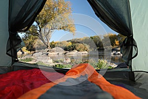 Camping tent with sleeping bags in wilderness