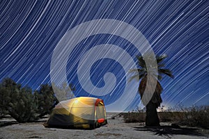 Camping Tent Under a Full Moon and Star Trails