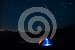 Camping tent under stars at night