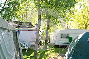 Camping tents caravan in green trees outdoor