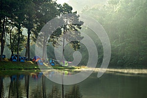 Camping tents at outdoor camp site near the lake with sunlight a