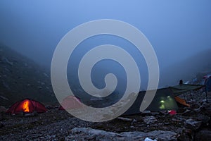 camping with tents and tourists in mountain valley at night and fog, Russian