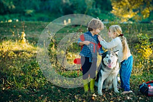 Camping tourism and vacation concept. Carefree childhood. A little blond girl and cute boy with her pet dog outdooors in