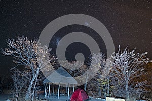 Camping under the starry sky and the majestic Magellanic Clouds, outstandingly bright, captured in Southern Africa. Tent and