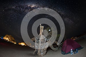 Camping under starry sky and Milky Way arc, with details of its colorful core, outstandingly bright, captured in Southern Africa.