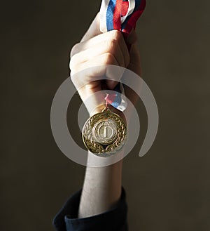 campion& x27;s hand holding a golden medal, simple winner lucky concept