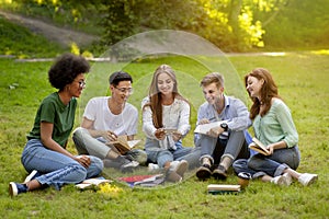 Campus Pastime. Joyful college students resting outdoors with smartphone, watching videos