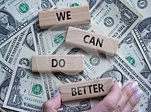 We Can Do Better symbol. Concept words We Can Do Better on wooden blocks. Beautiful dollar background. Businessman hand. Business