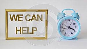 We can help, text in a gold frame , near a blue alarm clock