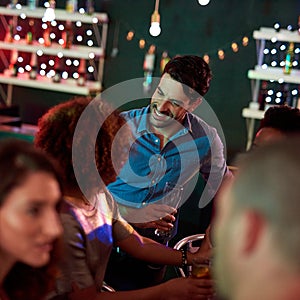 Can I offer you a drink. Shot of a group of people in a nightclub.