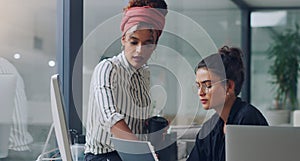 Can I take a look. Cropped shot of two attractive young businesswomen working together in the office.