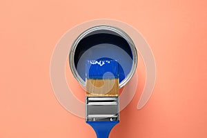 Can of paint and brush on orange background. Color of the year 2020 Classic blue