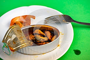 Can with pickled mussels, fork on plate
