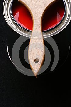 Can of Red Paint and Paintbrush on Black Background
