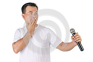 Can`t speak or stop taking concept. Portrait Asian man holding black wireless microphone and close his mouth by hand isolated on