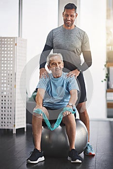 He can truly be proud of what he has achieved. a young male physiotherapist assisting a senior patient in recovery.