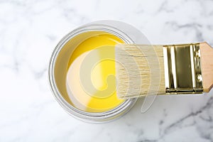 Can with yellow paint and brush