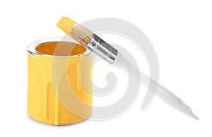 Can of yellow paint with brush on white background