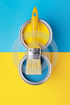 Can of yellow paint on yellow and blue background.