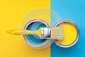 Can of yellow paint on yellow and blue background.