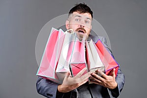 Can you imagine that. Telling friend about sales. bearded man in formal suit. stylish esthete with shopping bags