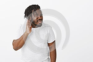 Can you repeat what you said. Portrait of curious good-looking plump african man with beard in white t-shirt, turning