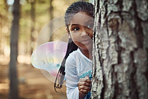 Can you spot a cute fairy in the forest. Shot of a little girl dressed up as a fairy and playing in the woods.
