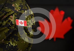 Canada Day. Flag of Canada on the military uniform and red Maple leaf on the background. Canadian soldiers. Army of Canada. Canada