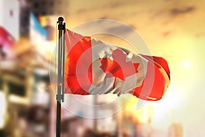 Canada Flag Against City Blurred Background At Sunrise Backlight