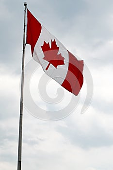 Canada flag with blue sky and clouds