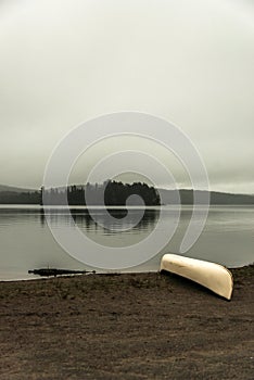 Canada Ontario Lake two rivers grey morning dark atmosphere Canoe Canoes parked beach water in Algonquin National Park