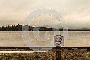 Canada Ontario Lake two rivers grey morning dark atmosphere sign beach no motor boats allowed in Algonquin National Park