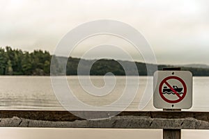 Canada Ontario Lake two rivers grey morning dark atmosphere sign beach no motor boats allowed in Algonquin National Park