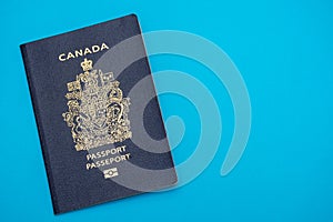 Canada passport on bright blue flat lay background. Travel and vacation concept