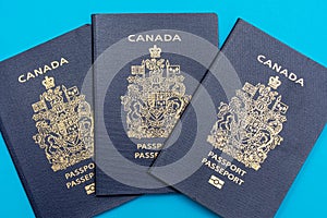 Canada passport on bright blue flat lay background. Travel and vacation concept