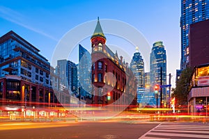 Canada, Toronto. The famous Gooderham building and the skyscrapers in the background. View of the city in the evening. Blurring tr