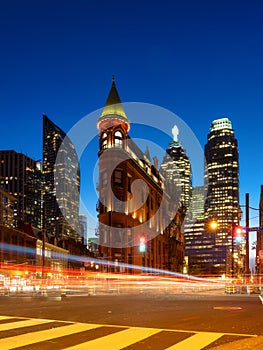 Canada, Toronto. The famous Gooderham building and the skyscrapers in the background. View of the city in the evening. Blurring tr