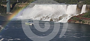 Canadian and Bridal Veil Falls including Maid of the Mist boat sailing on Niagara River with rainbow multicolor colors, Canada and