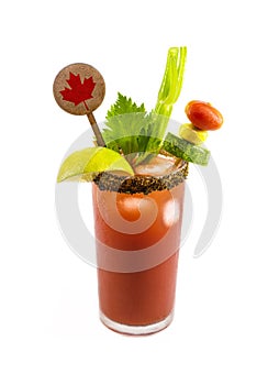 Canadian Caesar drink, typical Canadian drink, with hot sauce, celery, lemon, vodka and ice. Plate with Canadian flag decorating