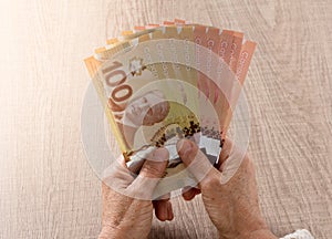 Canadian currency. Dollars. Above view of old retired person paying in cash