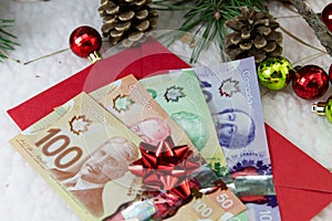 Canadian dollar bills and Christmas balls on a table, Canadian currency