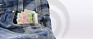 Canadian dollars of value 20, 50 and 100 in Blue Denim Jeans Pocket, Concept on earning money, saving money
