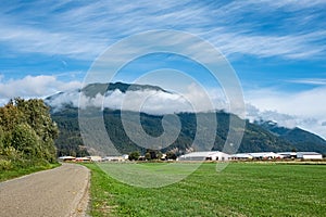 Canadian Farmland With Blue Cloudy Sky. Countryside Farm in the morning. Green agricultural field next to farm