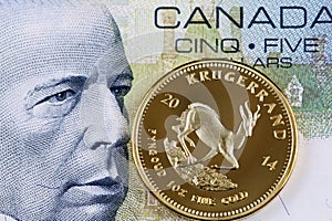 Canadian five dollar bill with a gold one ounce krugerrand