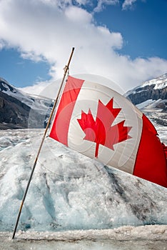 Canadian flag on Athabasca glacier in Columbia Icefield, Jasper National park, Rocky Mountains, Alberta Canada