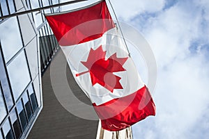 Canadian flag in front of a business building in Toronto, Ontario, Canada. Toronto is the biggest of Canada