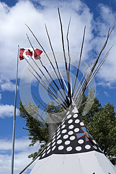 Canadian flag over top of teepee.